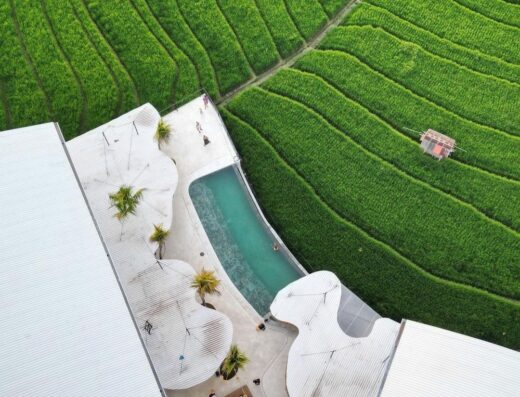 Bali Padel Academy aerial drone view showing infinity pool, sun loungers and surrounding rice fields