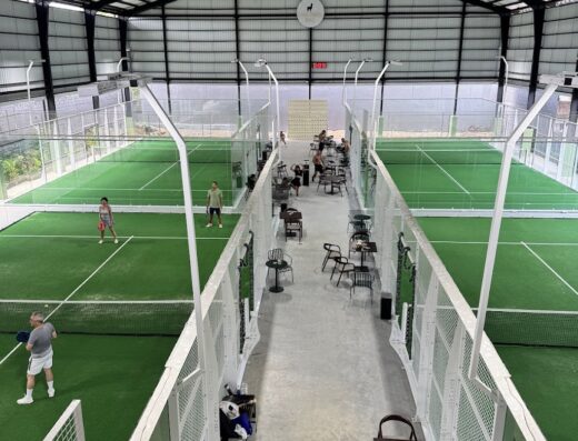 Indoor turf padel courts with cafe seating at Casa Padel Bali, Uluwatu