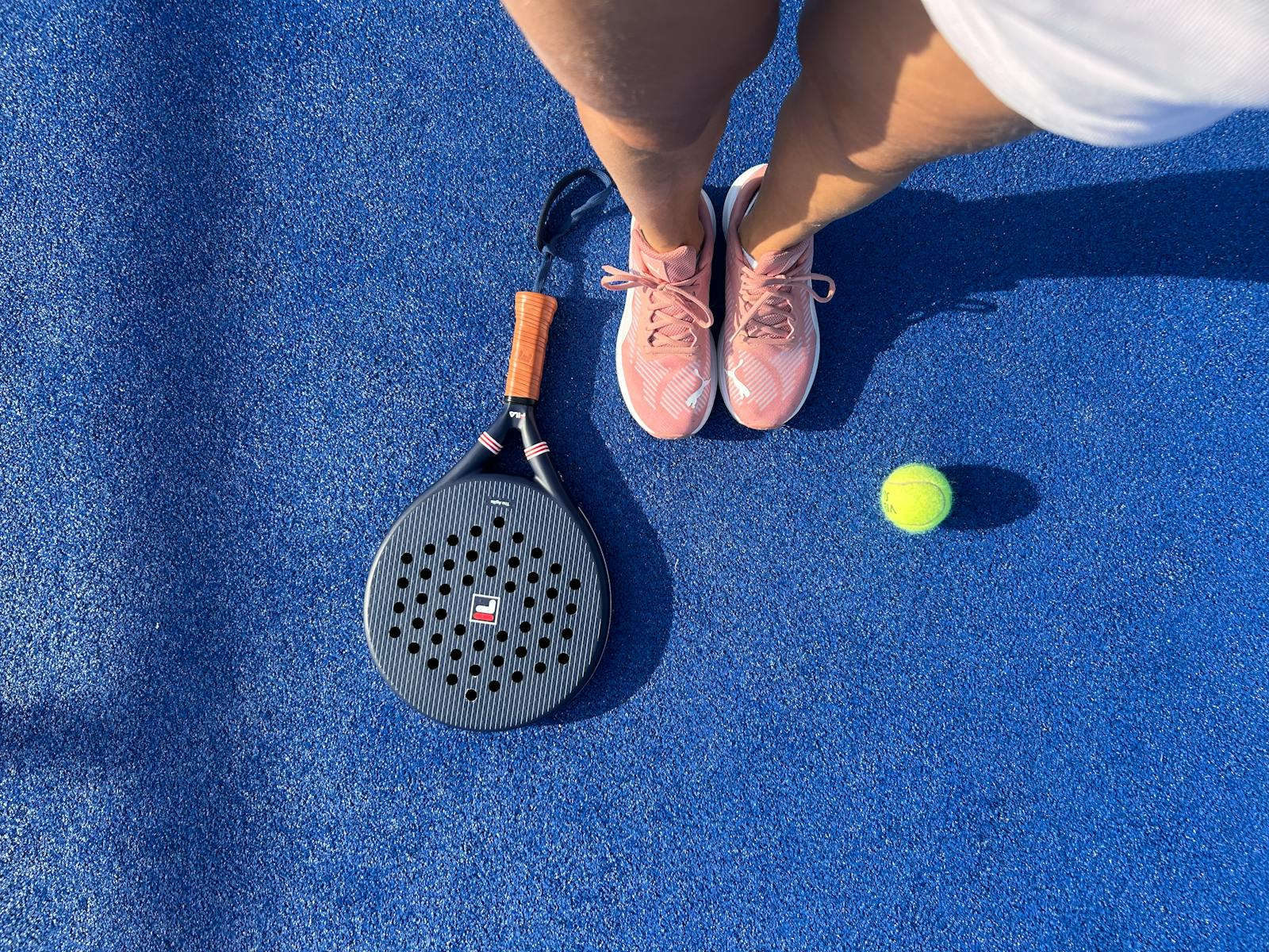 Padel shoes alongside a racket and balls - the kit a beginner padel player needs