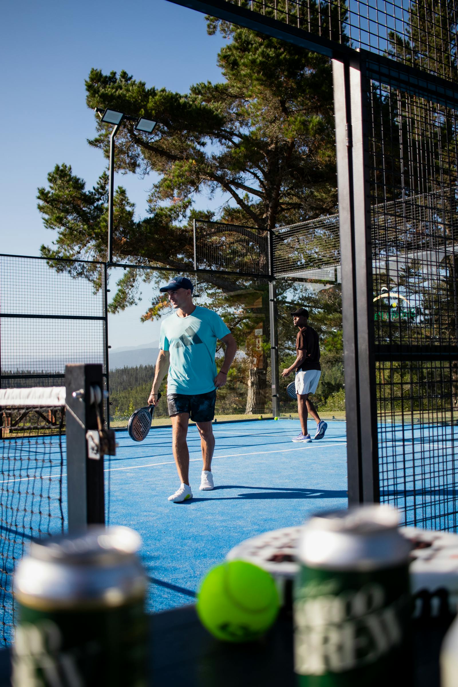 Two players on an outdoor padel court during a corporate Americano-format session