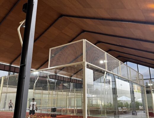 Covered glass-walled padel court under a timber roof at The Padel Society Bali