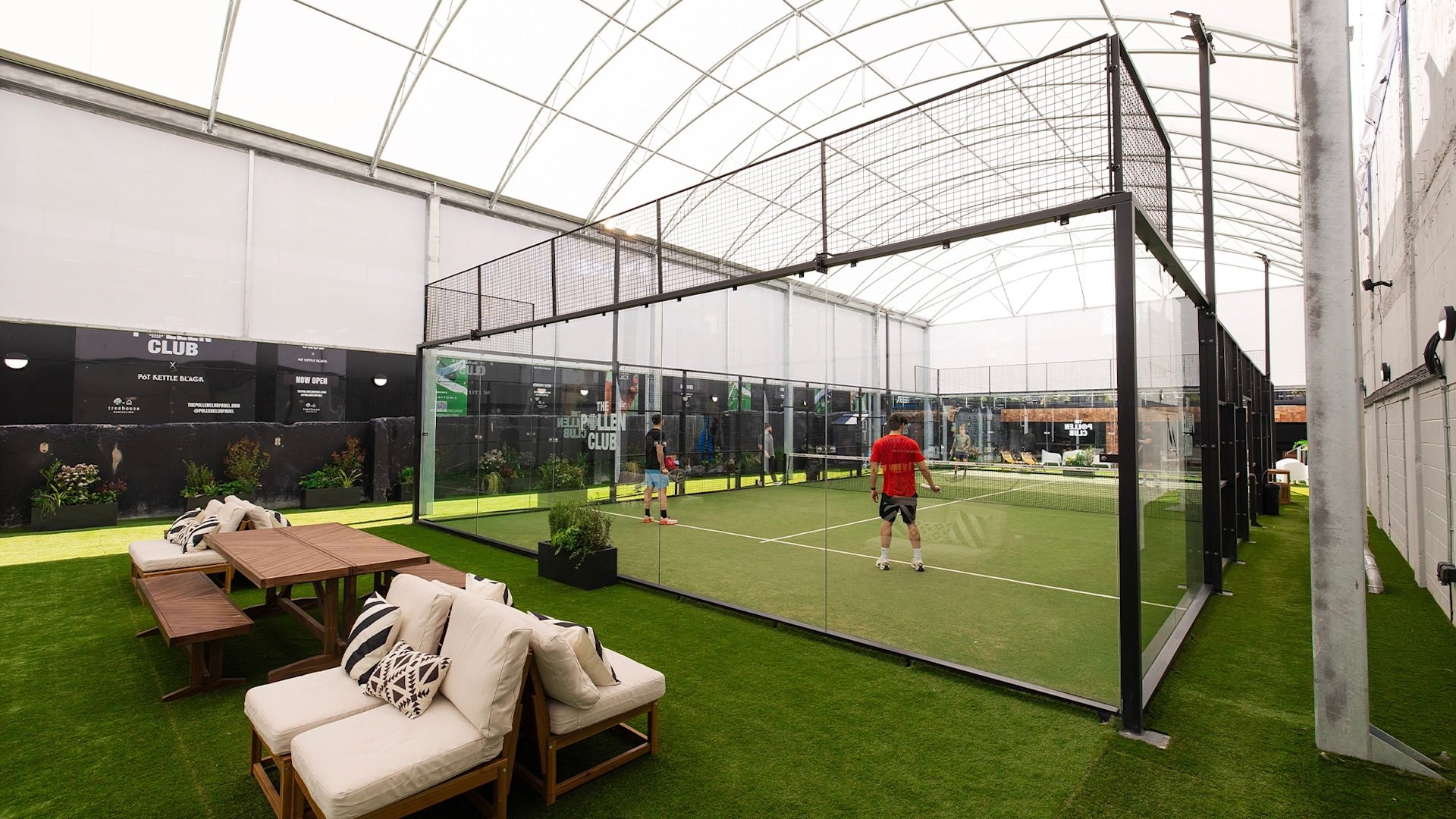 The Pollen Club Manchester canopy padel court with players mid-rally and lounge seating