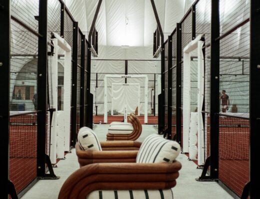 Lounge seating beside glass-walled padel courts at Brisas NYC, CityView Racquet Club