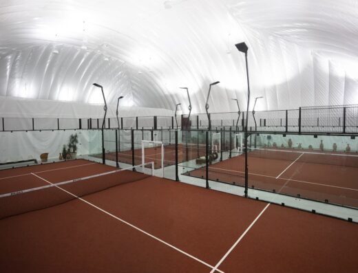 Glass-walled padel courts under the indoor dome at CityView Racquet Club
