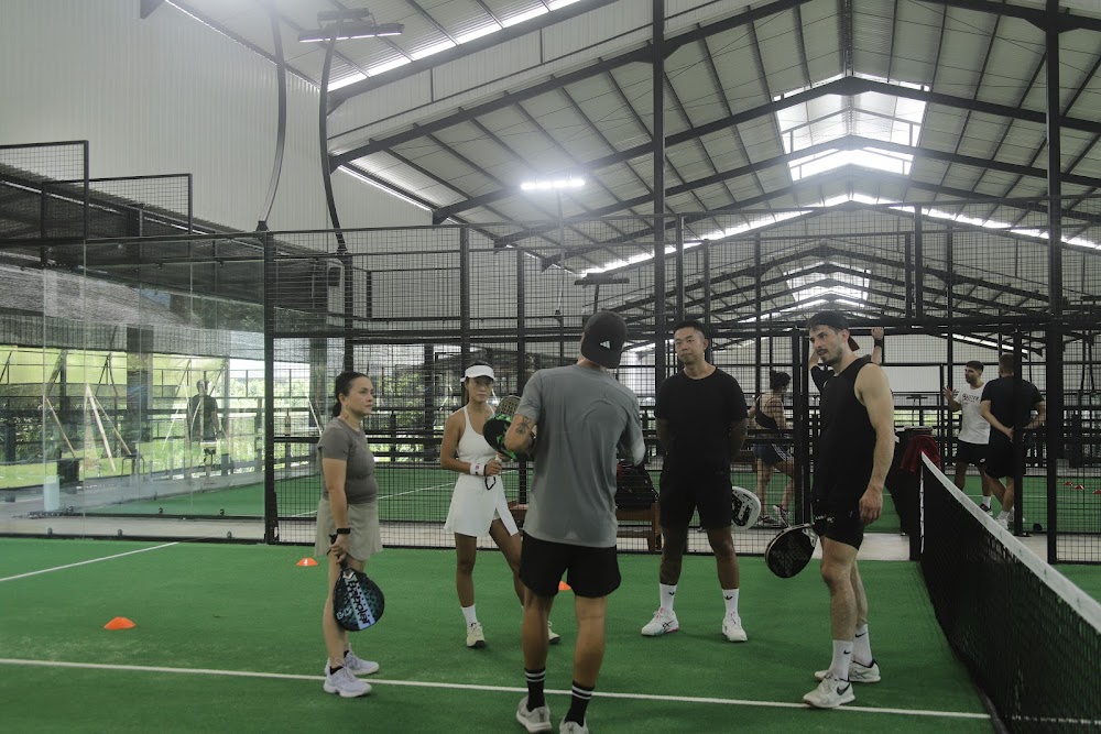 Players in a coaching session on an indoor padel court at Monster Padel Bali