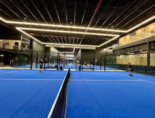 Indoor blue padel courts with glass walls at Padel Haus Dumbo, Brooklyn